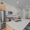 Furnished kitchen with a large center island with sink on hard-wood style flooring and stainless steel appliances 