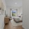 Furnished primary bedroom on hardwood-style floors and rug with white walls and a large window for natural lighting 