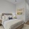 Furnished bedroom on hardwood-style flooring with an on-suite bathroom and white walls