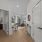 Corner two bedroom with hardwood-style flooring, white walls and doors looking out to the living room from entry way