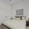 Furnished bedroom with a French door closet, white walls and doors on a hardwood-style flooring
