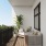Outside balcony with couches and a tree in the corner 